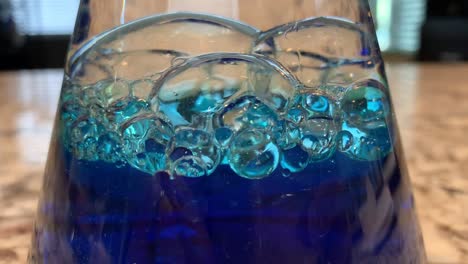 un experimento científico del océano en una botella para niños que mezcla aceite de bebé, agua y colorante azul para alimentos