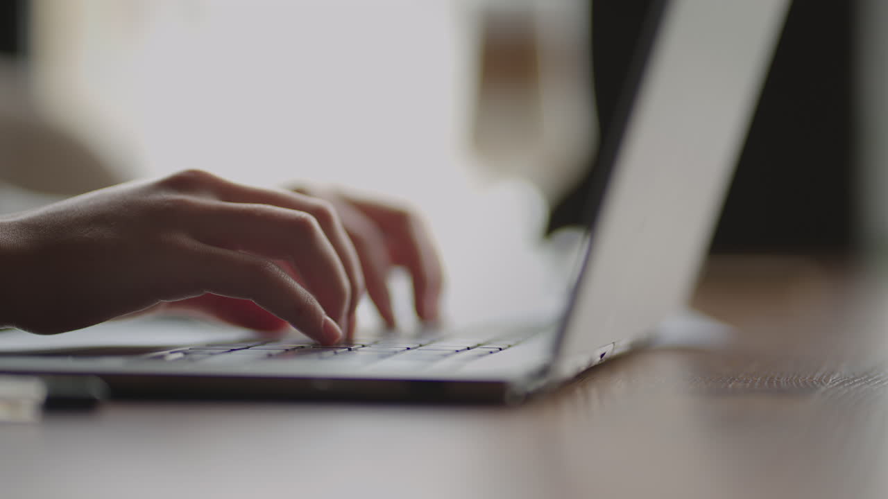 mujer joven de primer plano escribiendo en el teclado de una computadora portátil sentada en casa. trabajo remoto desde casa. oficina en casa