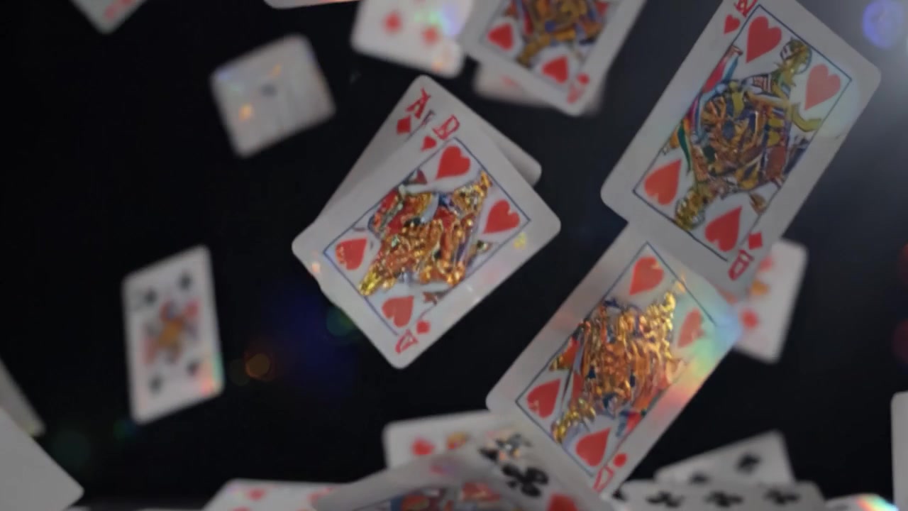 Uno spettacolo accattivante di carte da gioco che cadono in una serie ipnotizzante di colori e luci, mettendo in mostra l'eleganza e l'eccitazione dei giochi di carte in movimento