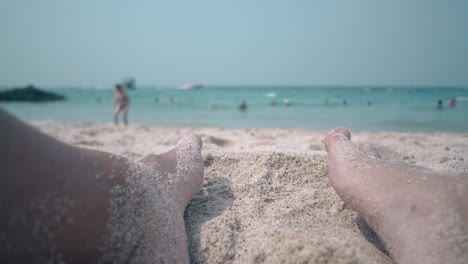 guy large legs on sandy beach against foaming ocean waves