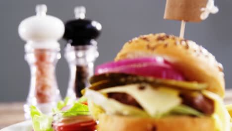 hamburger with salt and pepper shakers on table