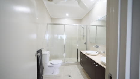 modern luxury apartment tiled flooring bathroom with dual vanity sinks above dark brown cabinet