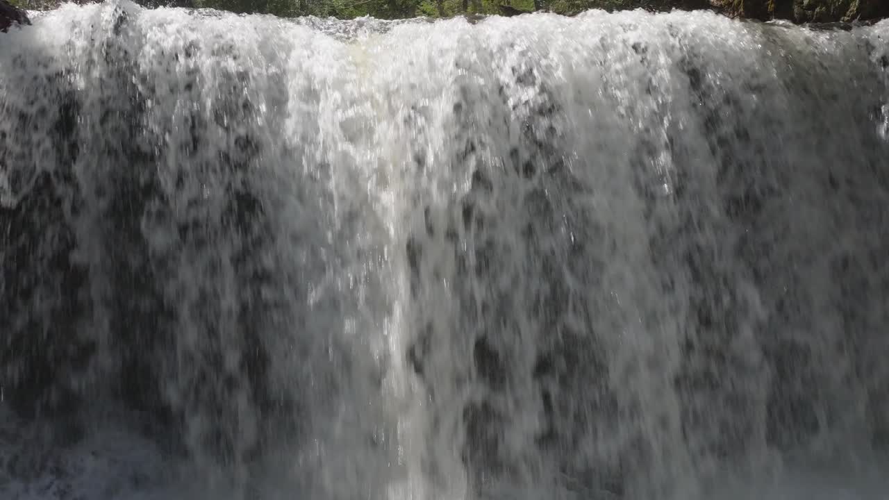 Water cascades over the edge of a waterfall in Owen Sound, Canada, on a sunny day