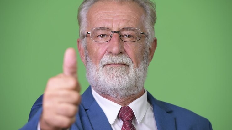 Affascinante uomo d'affari anziano con barba su sfondo verde