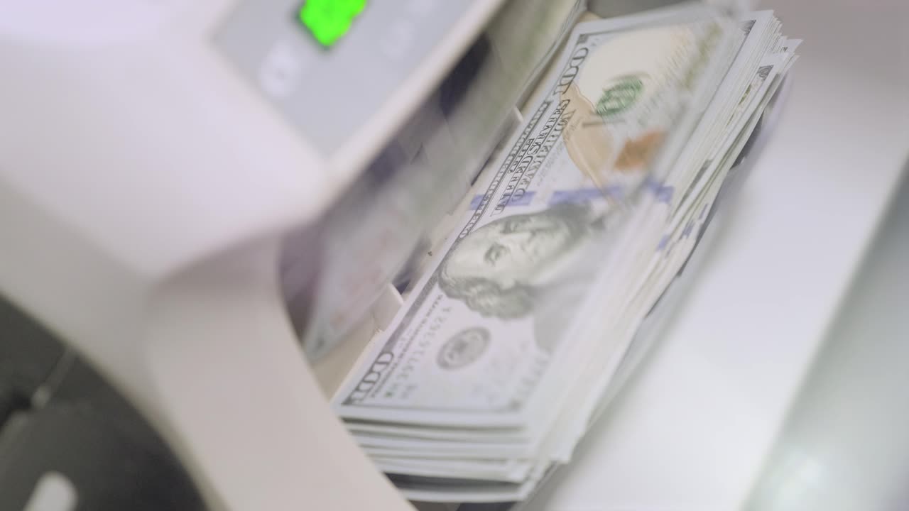 la máquina calculadora cuenta los billetes de un dólar mil dólares. 100 dólares