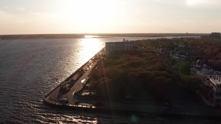 Ripresa aerea in discesa e panoramica del muro di contenimento di South Battery al confine del White Point Garden durante il tramonto a Charleston, Carolina del Sud