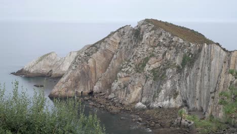 dramatic cliffs meet the sea at silence beach, asturias, spain, under a quiet sky
