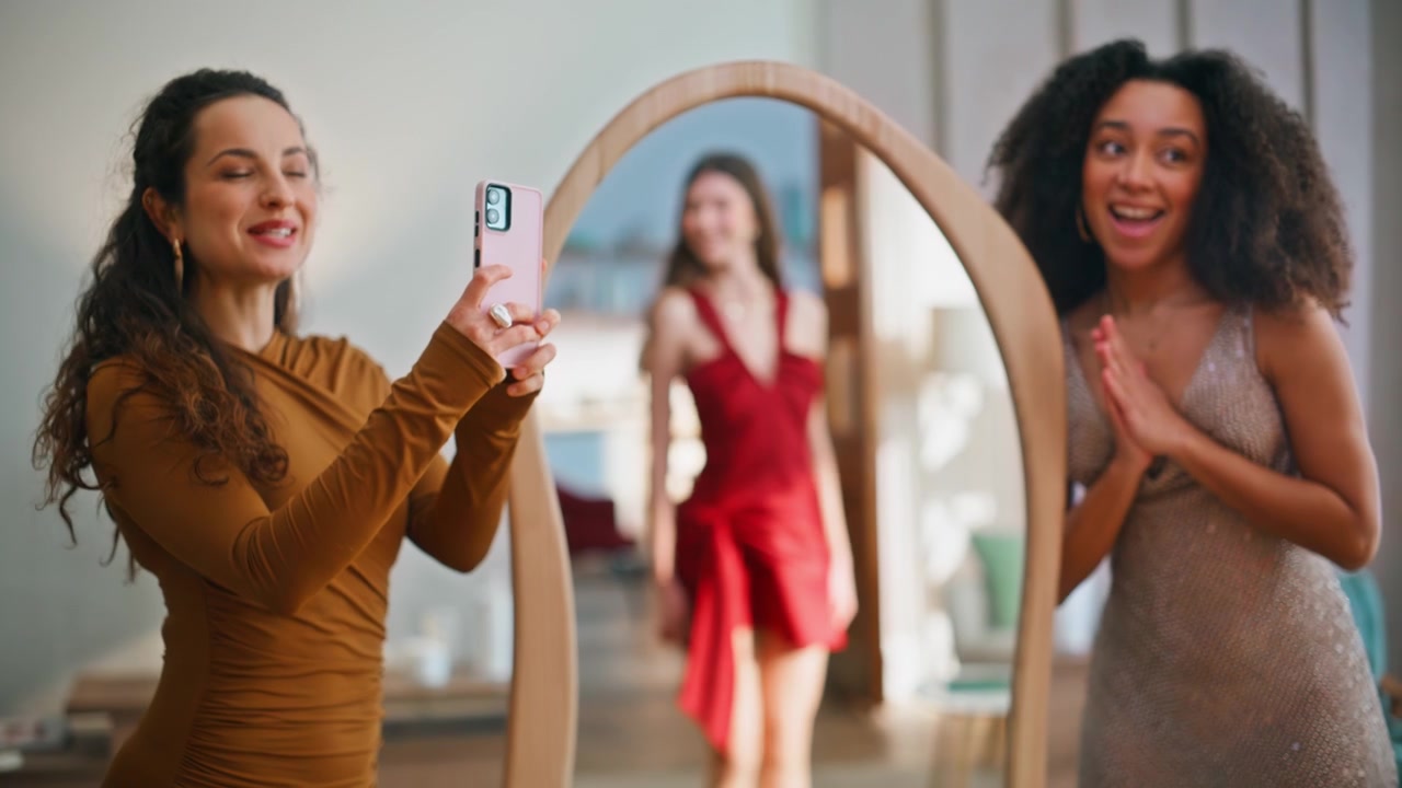 Ragazze in festa che scattano foto con abiti eleganti, preparandosi per un evento serale, primo piano.