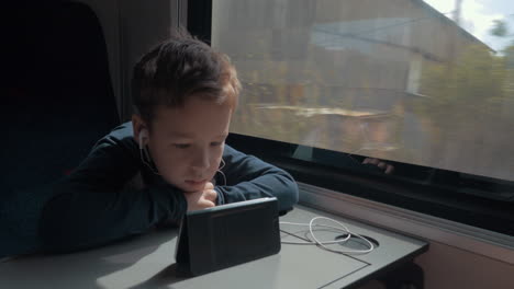 Niño-Con-Auriculares-Viendo-Dibujos-Animados-En-El-Celular-En-El-Tren