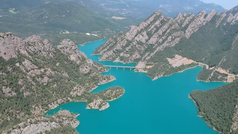 Vistas-Aéreas-De-Un-Lago-En-Los-Prepirineos-En-Cataluña-Con-Hermosas-Montañas-Que-Lo-Rodean