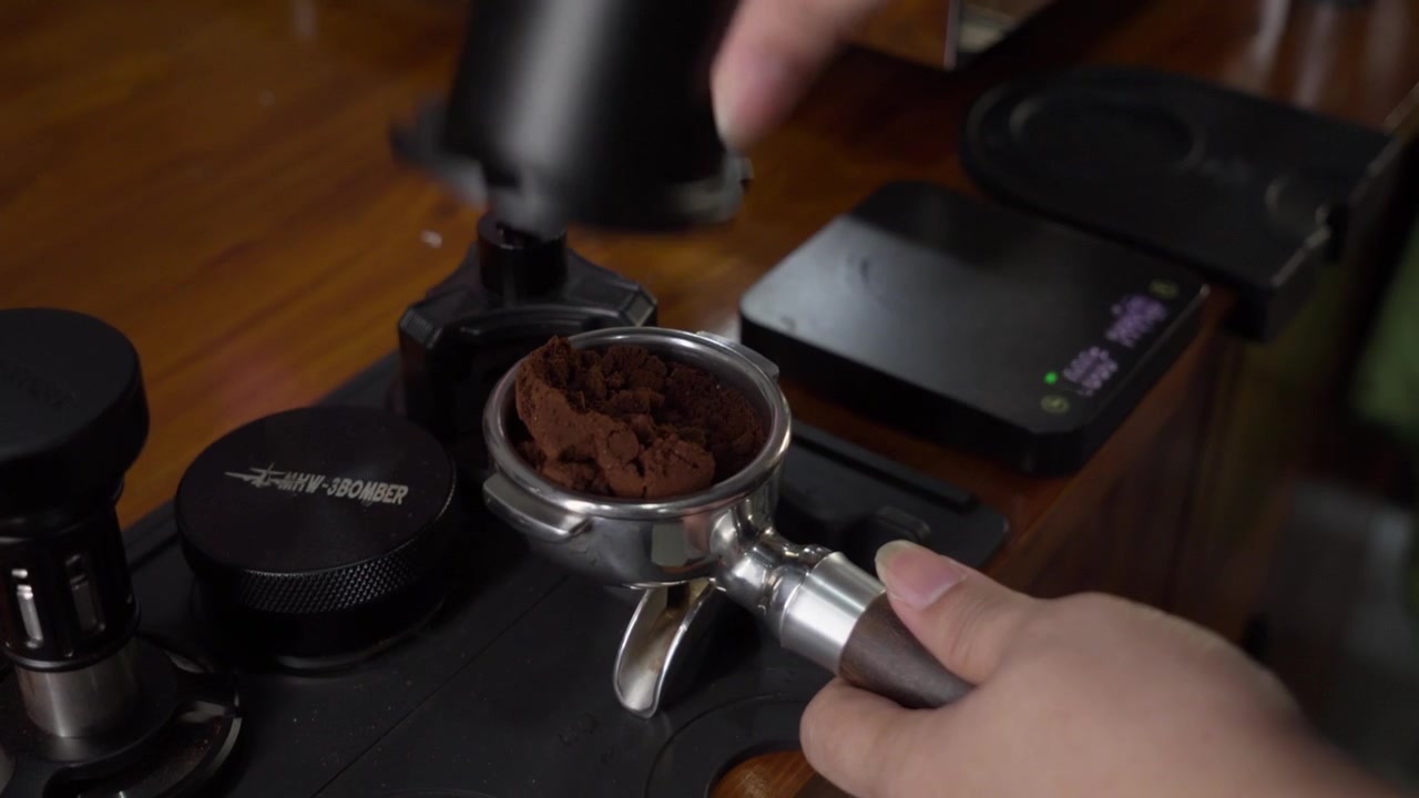 Barista che aggiunge caffè macinato nel portafiltro della macchina da caffè espresso, preparazione dell'espresso.