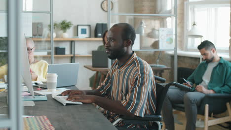 african american businessman with disability working on computer in office