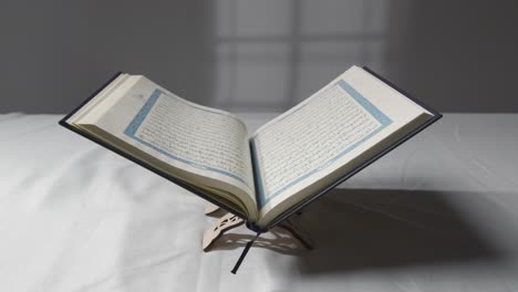 a handheld shot of the quran on covered surface