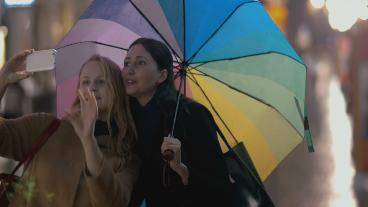 두 소녀가 비가 오는 날 셀피를 찍습니다.