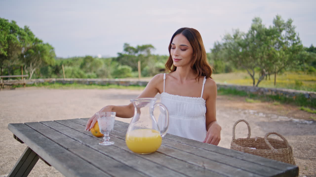 Satisfied woman enjoying summer holidays at village yard. Lady taking oranges