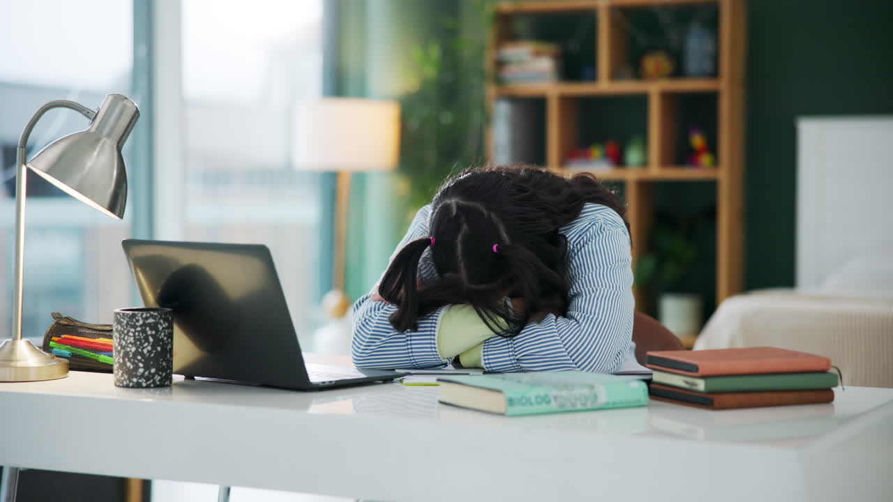 Studente stanco che dorme alla scrivania con laptop e libri