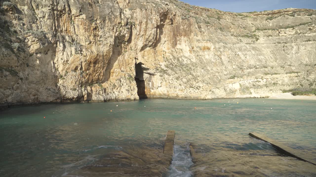 zona de cuevas marinas interiores en malta con boyas en el agua en un día soleado de invierno en la isla de gozo