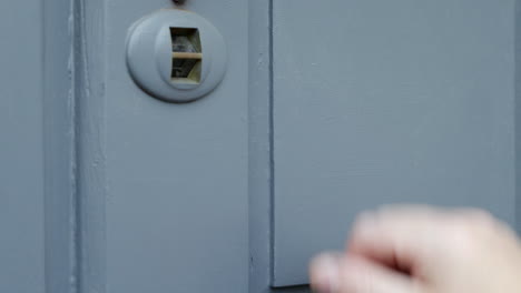 a man knocking on a grey wooden door