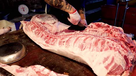 butcher expertly trims and prepares meat on table.