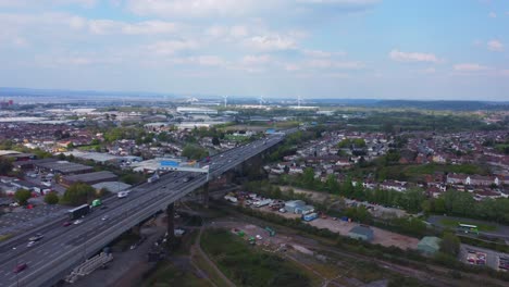 Statische-Drohnenaufnahme-über-Dem-Fluss-Avon-Mit-Blick-Nach-Norden,-Darunter-Die-Stark-Befahrene-Autobahn-M5-Voller-Verkehr-Und-In-Der-Ferne-Windkraftanlagen