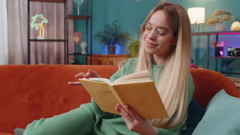 Mujer-Joven-Relajante-Libro-Interesante-Pasando-Páginas-Sonriendo-Disfrutando-De-La-Literatura-Descansando-En-El-Sofá