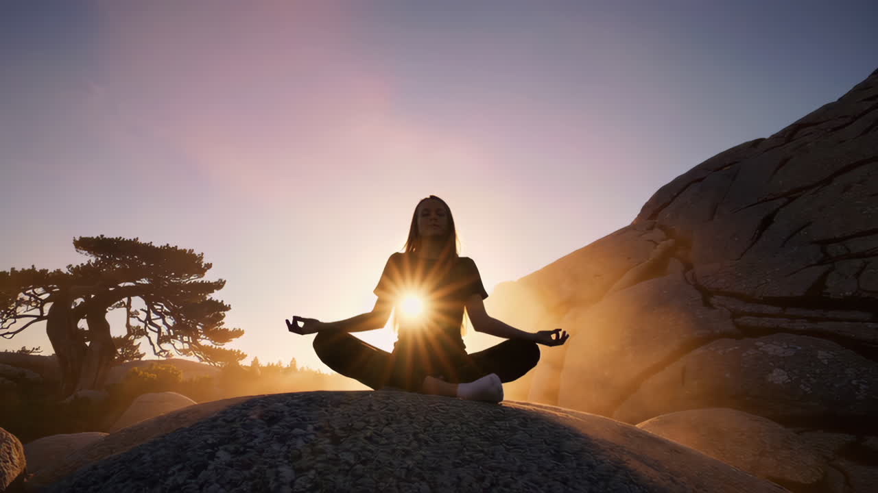 Woman Meditating at Sunrise in Mountains