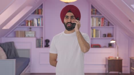 hombre indio sikh feliz hablando por teléfono y sonriendo