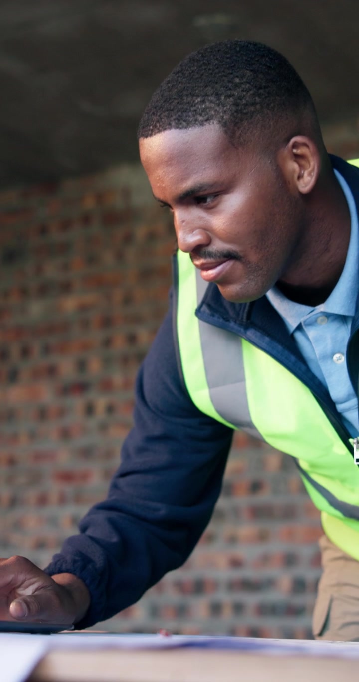 Construction Engineer Reviewing Blueprints on Site
