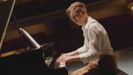 pianist playing piano in concert hall