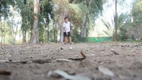 Un-Niño-Jugando-A-Las-Canicas-En-El-Parque-Lanza-Su-Canica-Hacia-La-Cámara