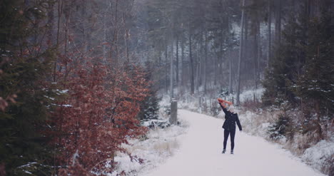 woman moving scarf in in winter in forest