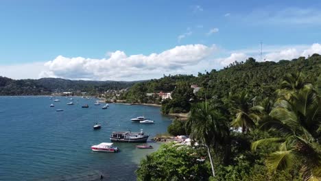 Vista-Aérea-De-Playa-Tropical,-Bahía-Con-Botes-Y-Paisaje-Montañoso,-Península-De-Samaná,-República-Dominicana