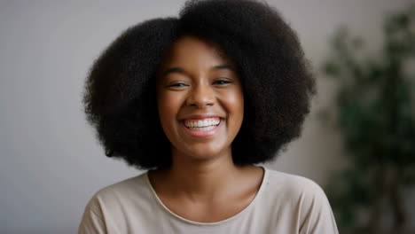 smiling young black woman with afro hair portrait