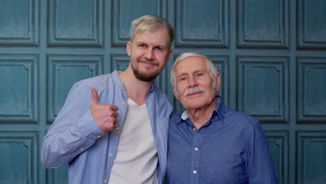 happy different male generations family of senior father and adult son or grandson showing thumbs up