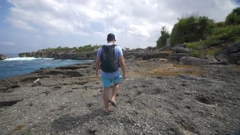 tourist walking along bali coastline