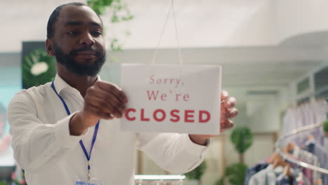 man closing down clothing shop