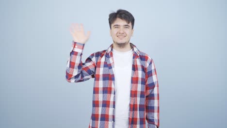 카메라를 향해 손을 흔드는 행복한 남자.