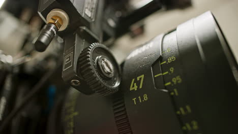 primer plano de un motor de enfoque en una cámara de cine profesional girando el anillo de enfoque de una lente primaria esférica de gama alta