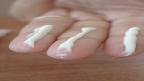 close-up of a hand with white cream applied to the fingers