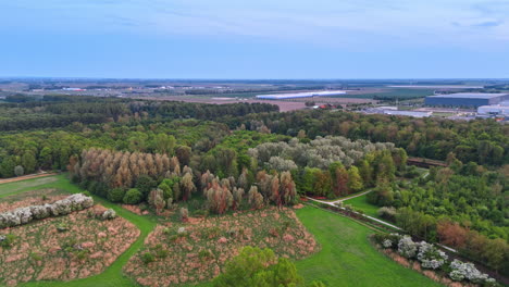 urban greenery and fields nearby. drone view of rich vegetation surrounding an industrial area, showcasing a blend of nature and development