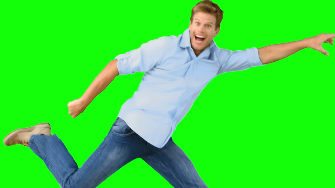 Uomo sorridente che salta su schermo verde