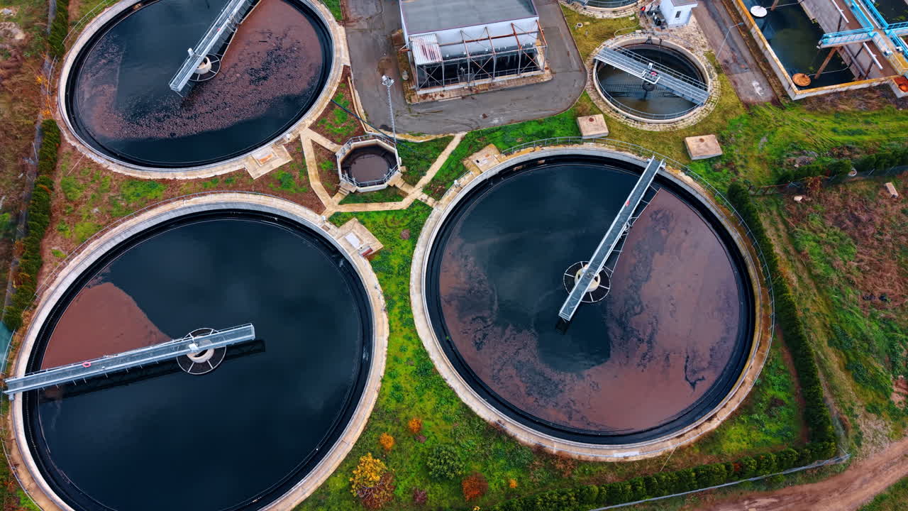 Sewage water filling the round reservoirs at the territory of modern water treatment plant. Natural resources saving concept. Aerial view