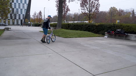 guy riding a bmx bike in a skatepark,performing stunts and failing