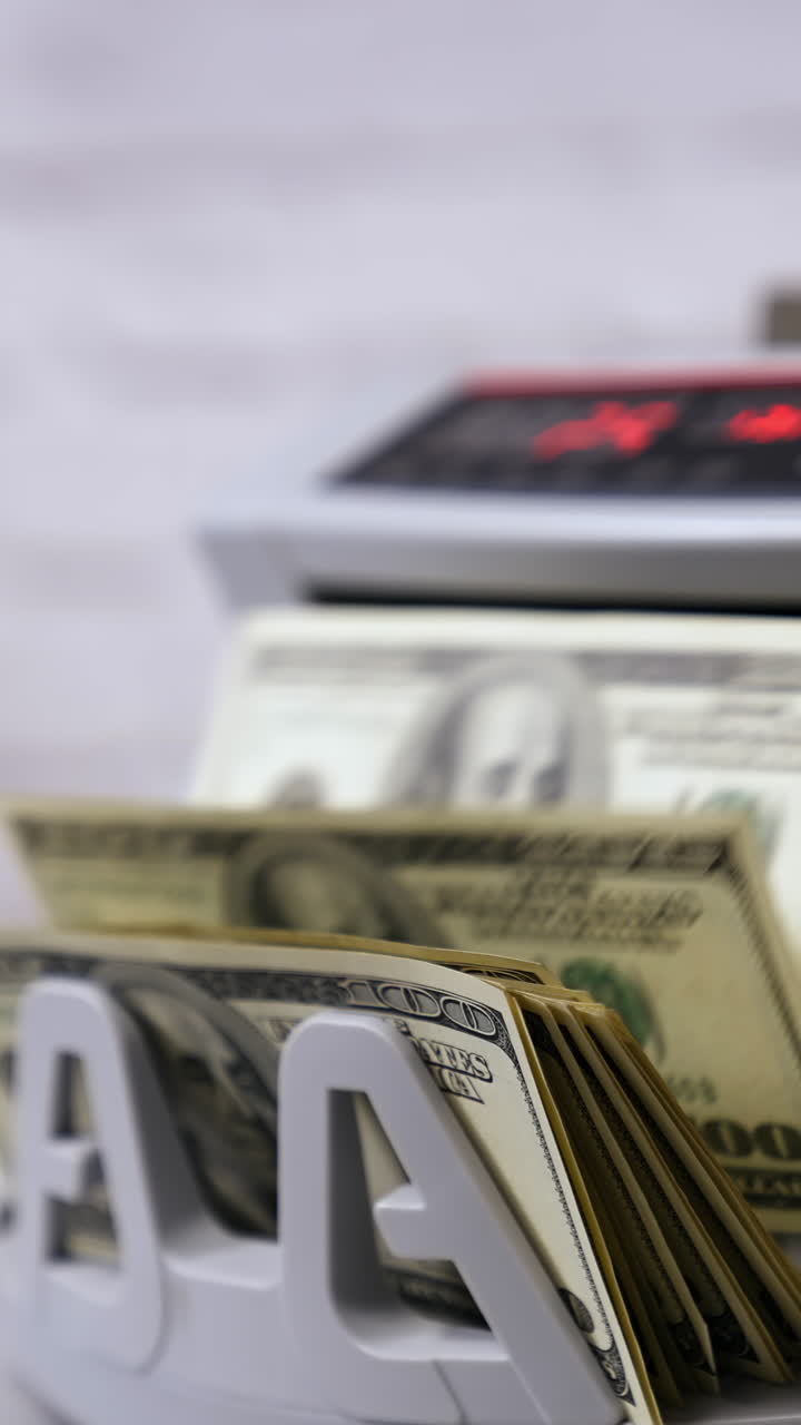 Clerk hand counting dollars with electronic money counter machine at ...