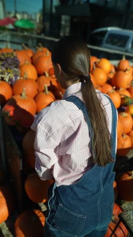 woman picking pumpkins at a fall market