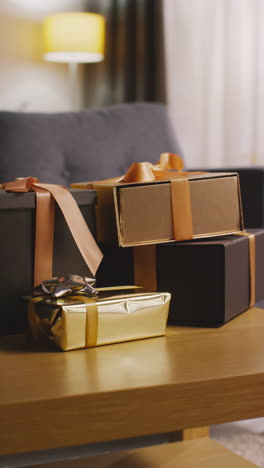 vertical video of pile of presents in gift wrapped boxes decorated with ribbon on table in lounge 1