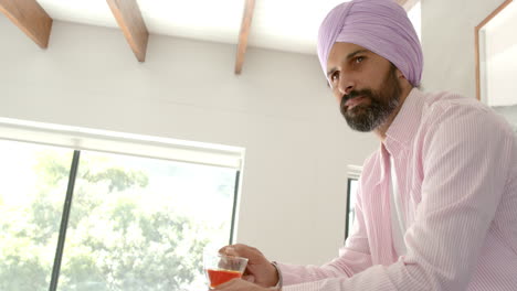drinking tea, indian man in turban relaxing at home near window