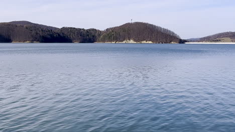 the solina dam as seen from the shore of lake solina