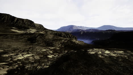 rugged landscape with mountains and valley under a cloudy sky