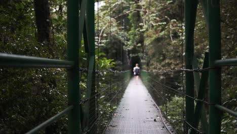 Mujer-Caminando-Sobre-El-Puente-Colgante-Bosque-Nuboso-De-Monteverde---Costa-Rica